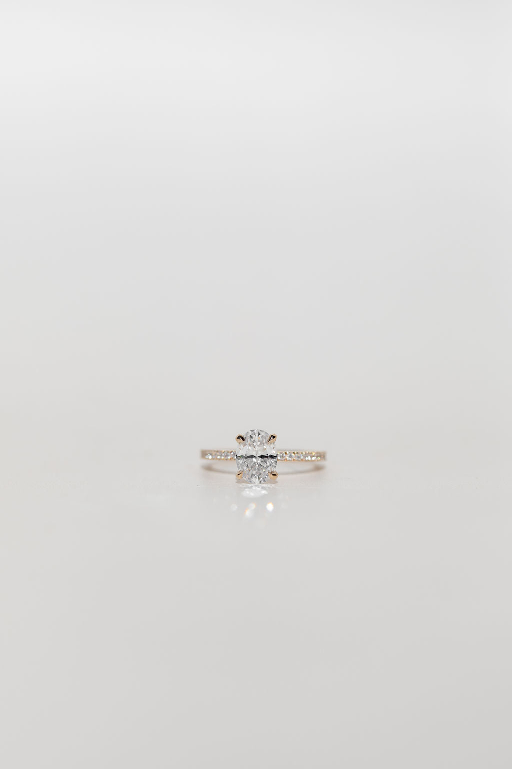 Oval diamond engagement ring with pave diamonds in the band