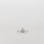Pear cut diamond engagement ring with diamond band