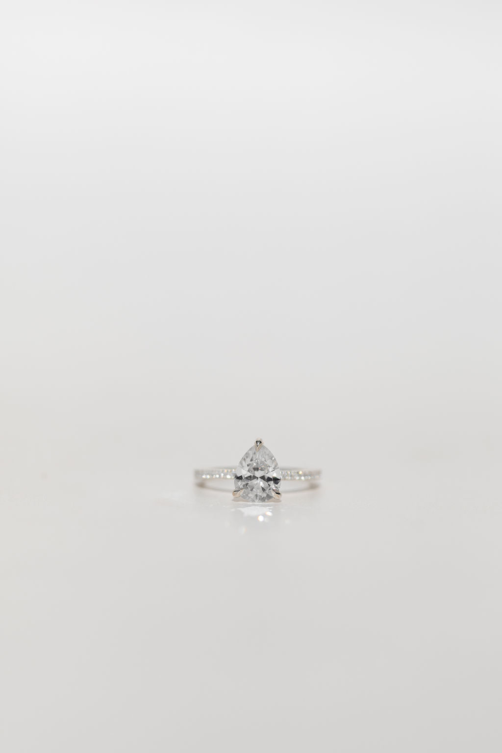 Pear cut diamond engagement ring with diamond band