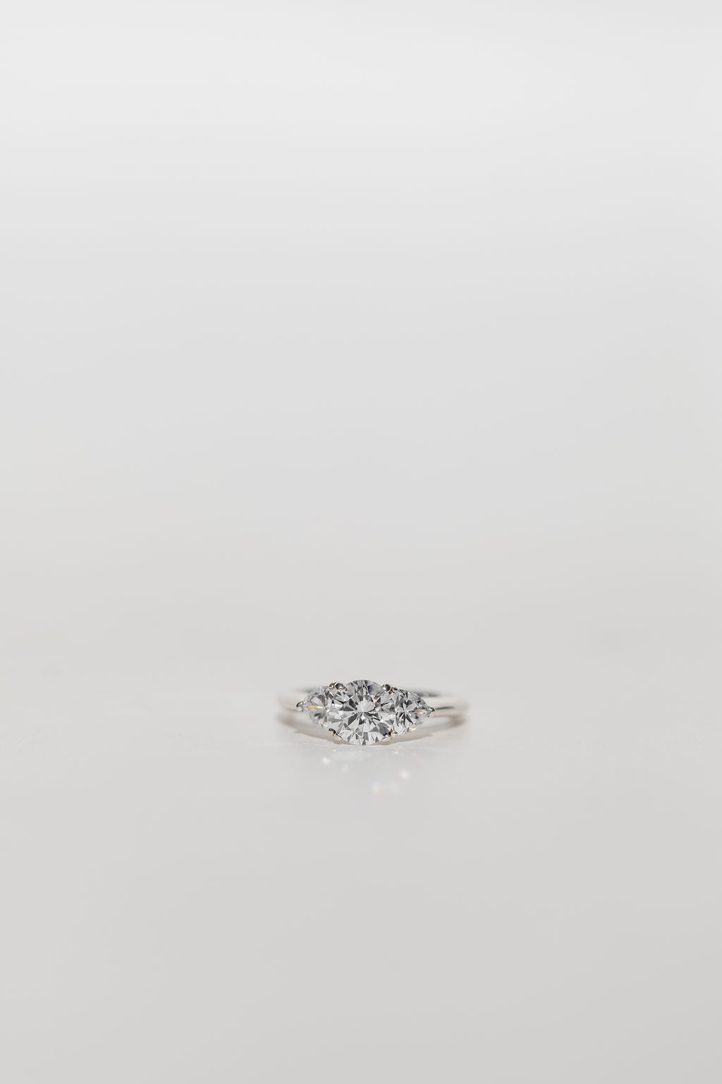 Trilogy Three stone ring with a round cut centre diamond and brilliant cut side stones