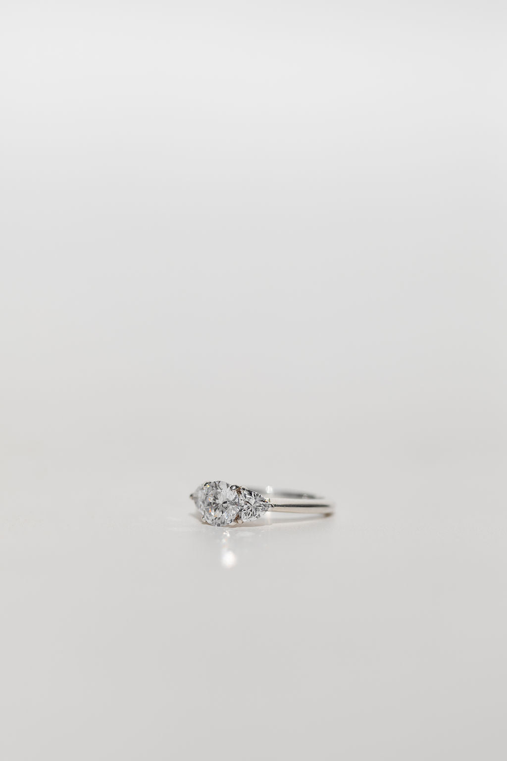 Trilogy engagement ring with a round cut diamond centre and brilliant cut side stones