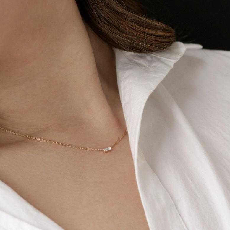 model wearing yellow gold baguette cut diamond pendant yellow gold