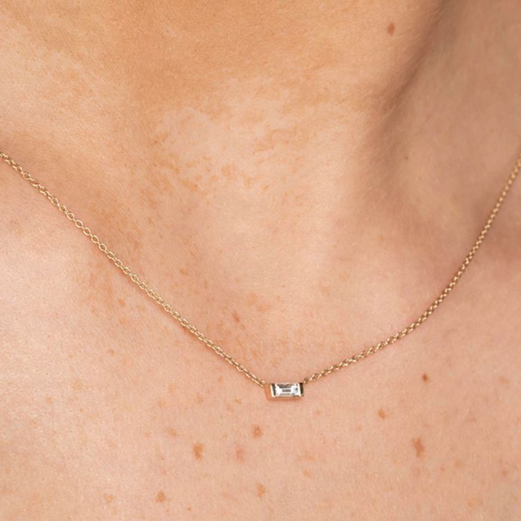 model wearing yellow gold baguette cut diamond pendant