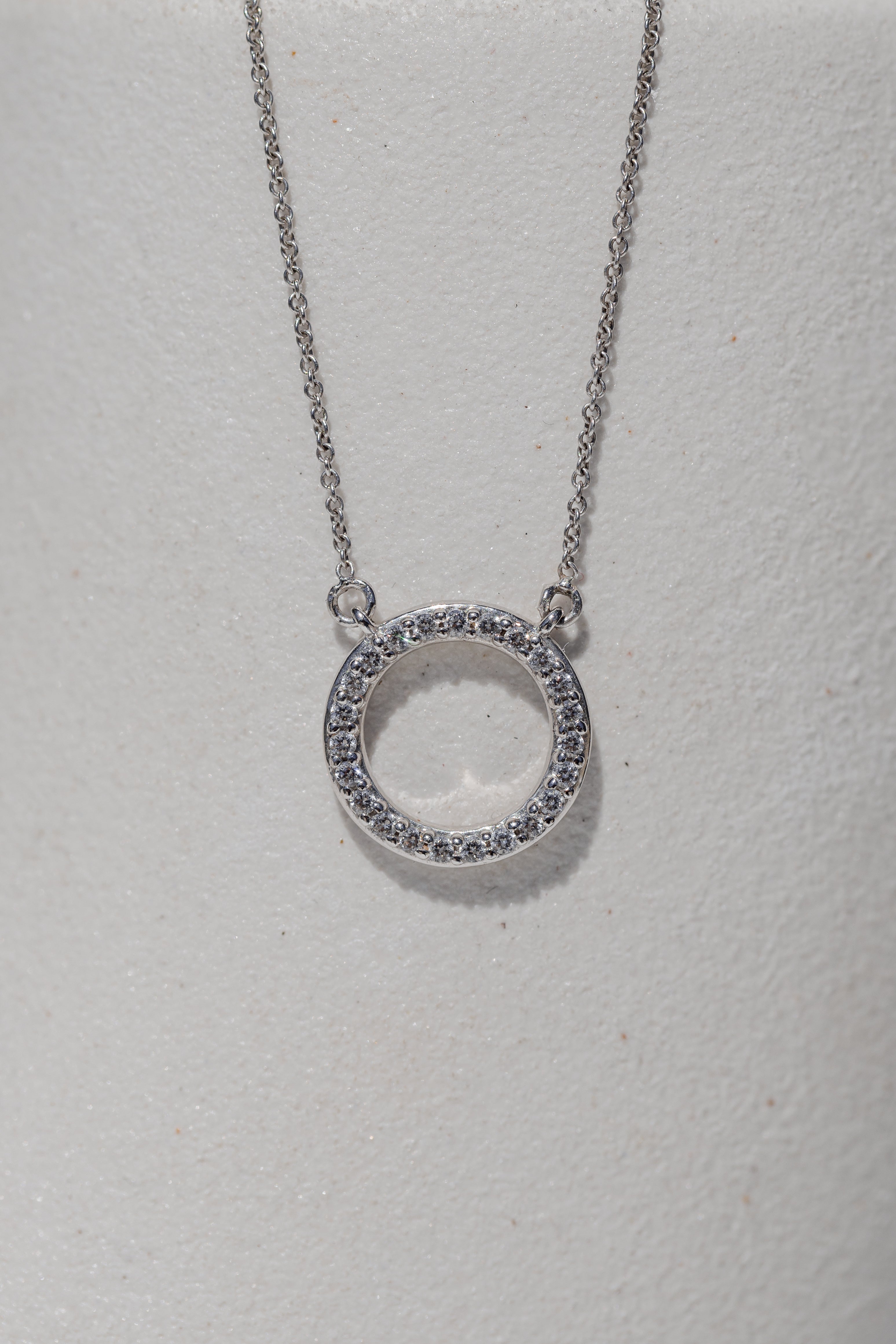 circle pendant with a halo of diamonds