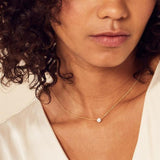 model wearing yellow gold claw set diamond pendant