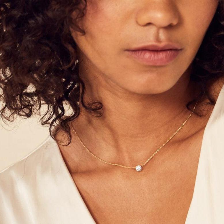 model wearing yellow gold claw set diamond pendant