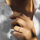 White gold diamond ring with shared claws on a woman with a white shirt