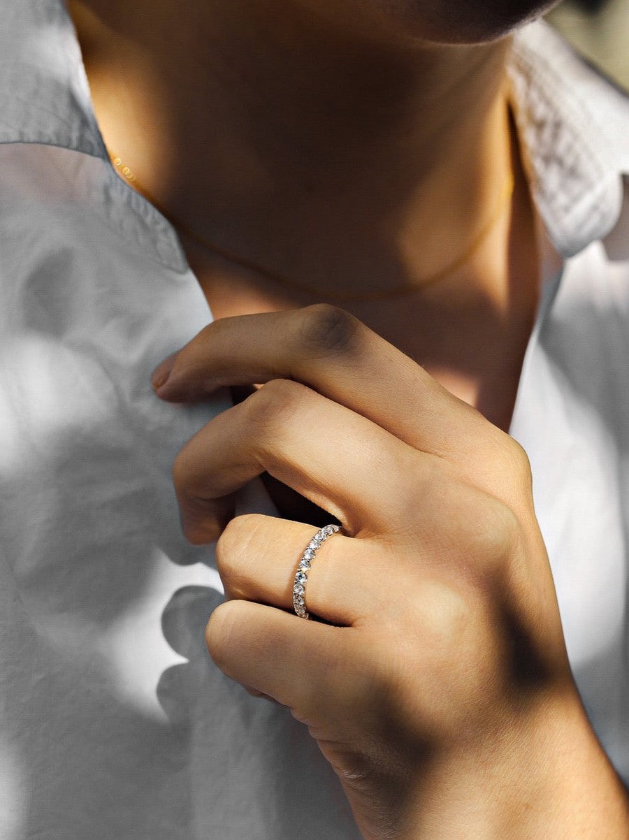 White gold diamond ring with shared claws on a woman with a white shirt