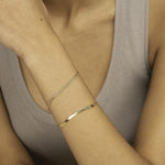 Woman wearing yellow gold herringbone bracelet