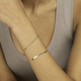Woman wearing yellow gold herringbone bracelet