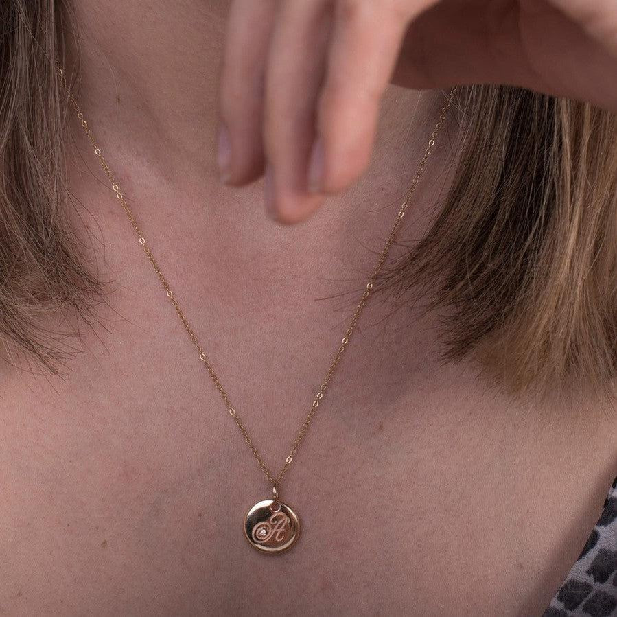 yellow gold disc pendant with engraved letter