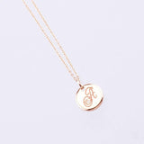 yellow gold disc pendant with engraved letter