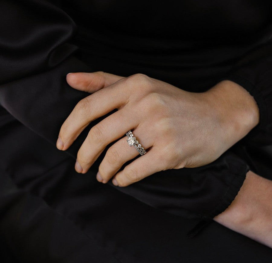 white gold diamond engagement ring with round diamond in the centre on 4 claws with a claw set diamond band and a diamond wedding ring with single claw