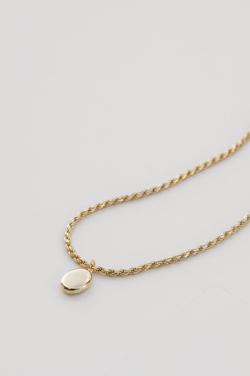 oval locket on gold rope chain