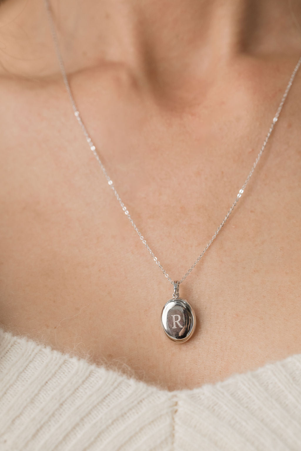 silver oval locket engraved on chain