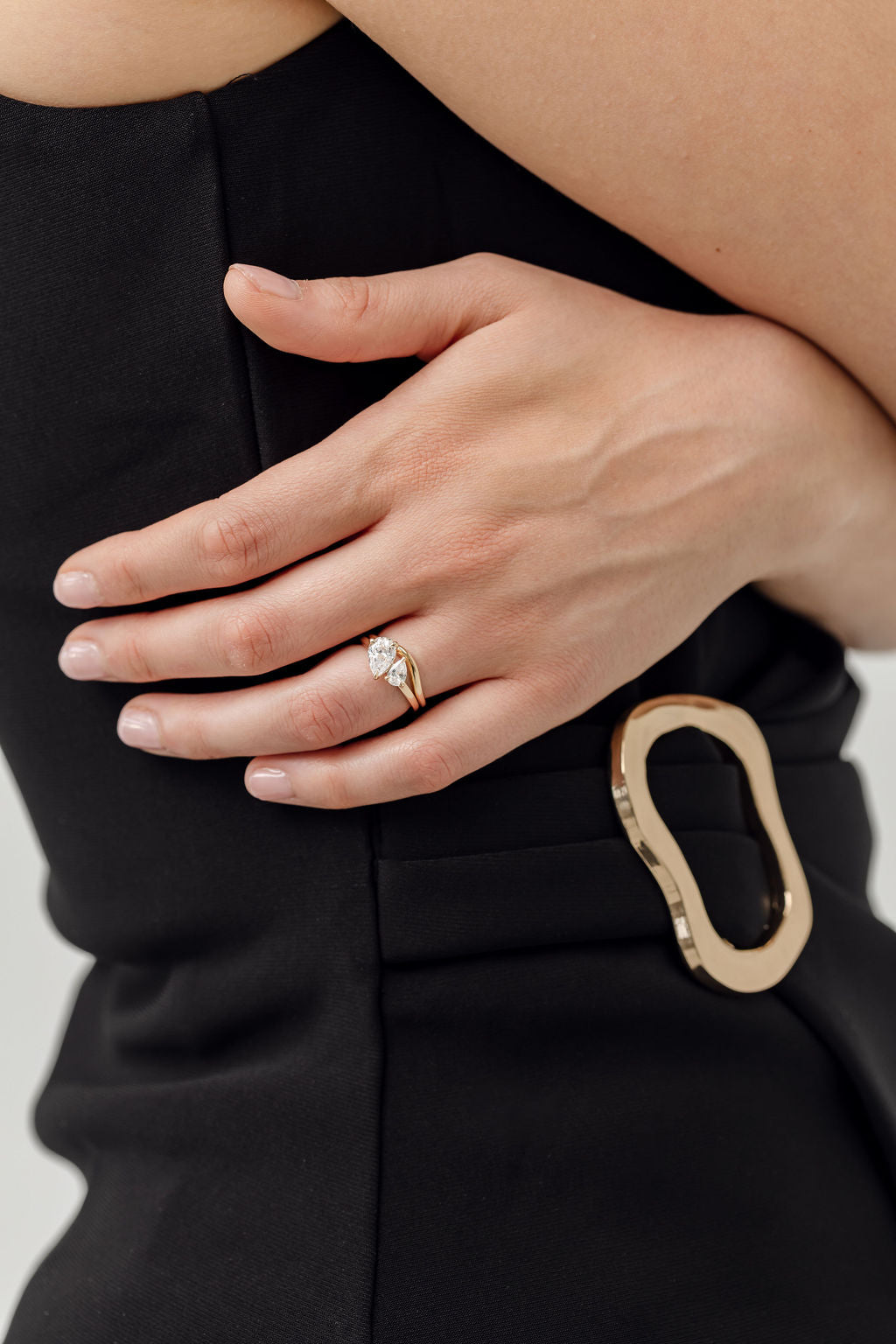 toi et moi pear cut diamond engagement ring with gold curved wedding ring