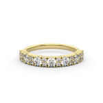 A round diamond sparkly brilliance in a statement diamond ring, set in a gold band with two smaller diamonds alternating. 