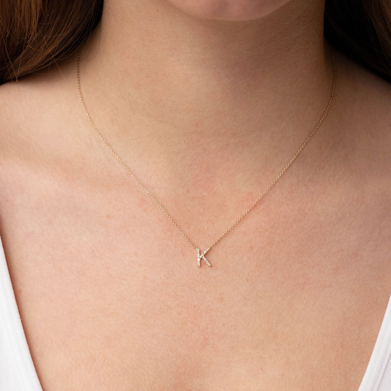 Model wearing diamond initial pendant necklace  in gold
