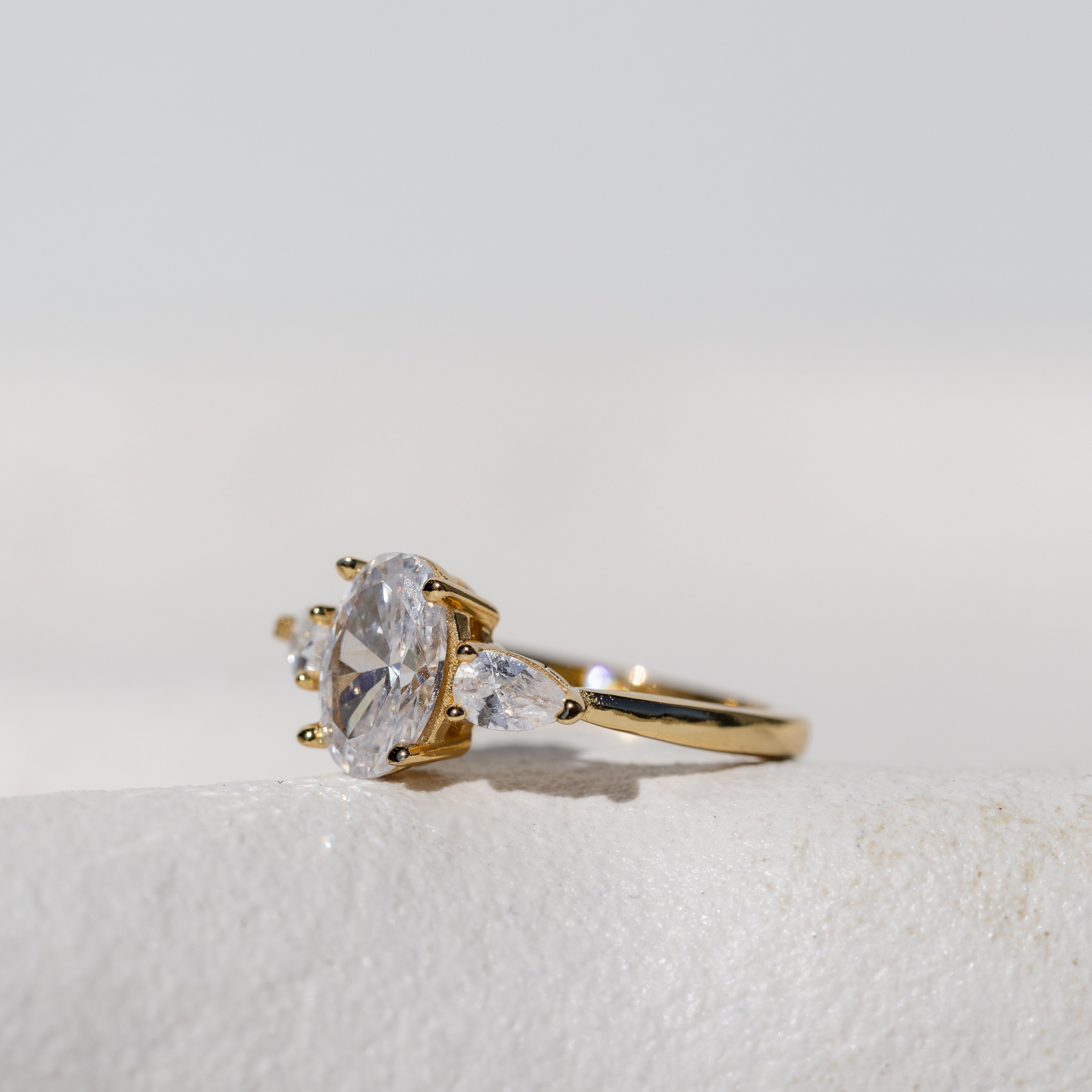 OVAL WITH PEAR SIDE STONES THREE STONE TRILOGY RING