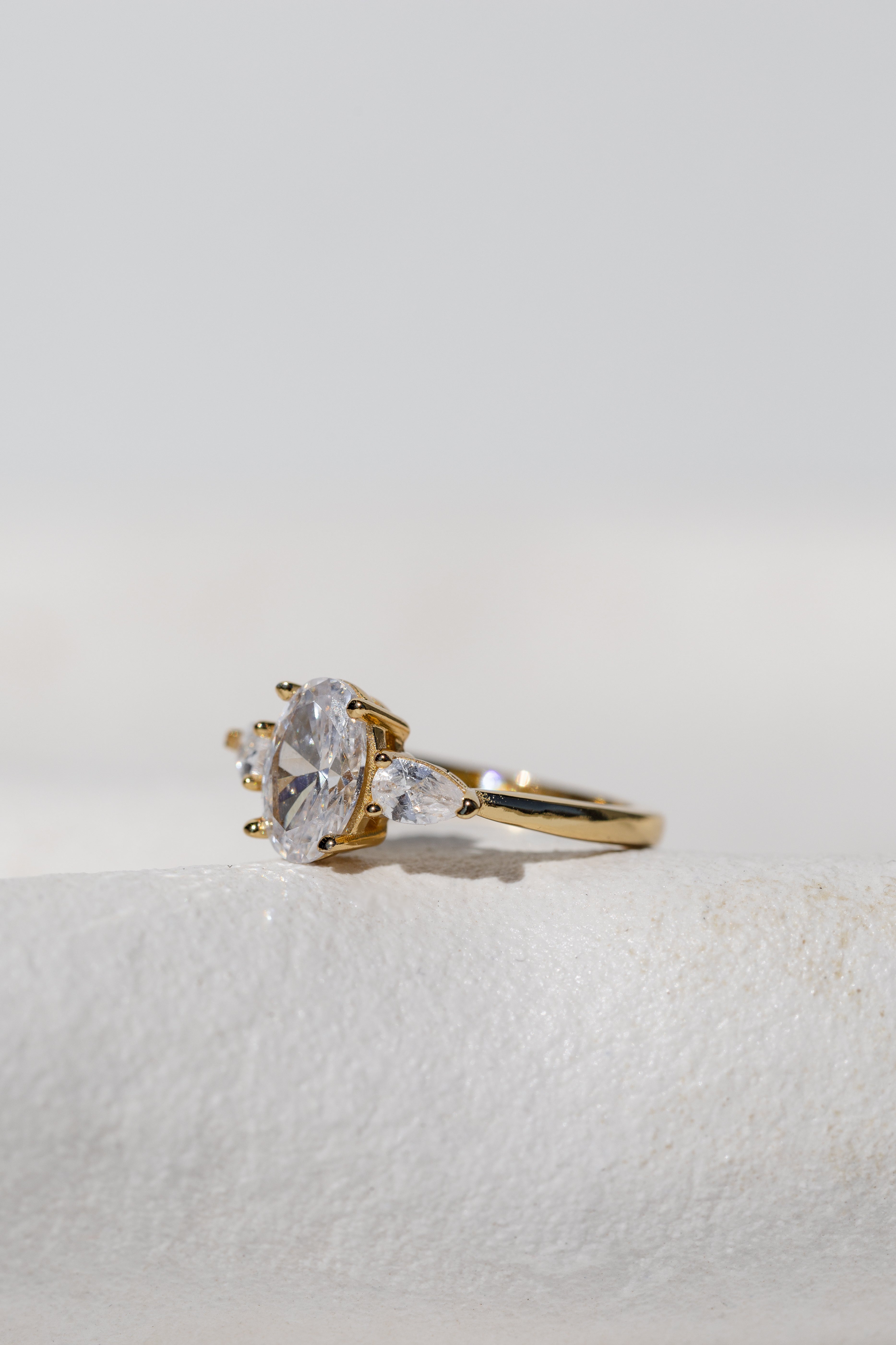 OVAL WITH PEAR SIDE STONES THREE STONE TRILOGY RING