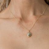 model wearing bead chain necklace with gold oval pendant