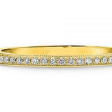 Pave set diamonds and a millgrain edge wedding ring  yellow gold 