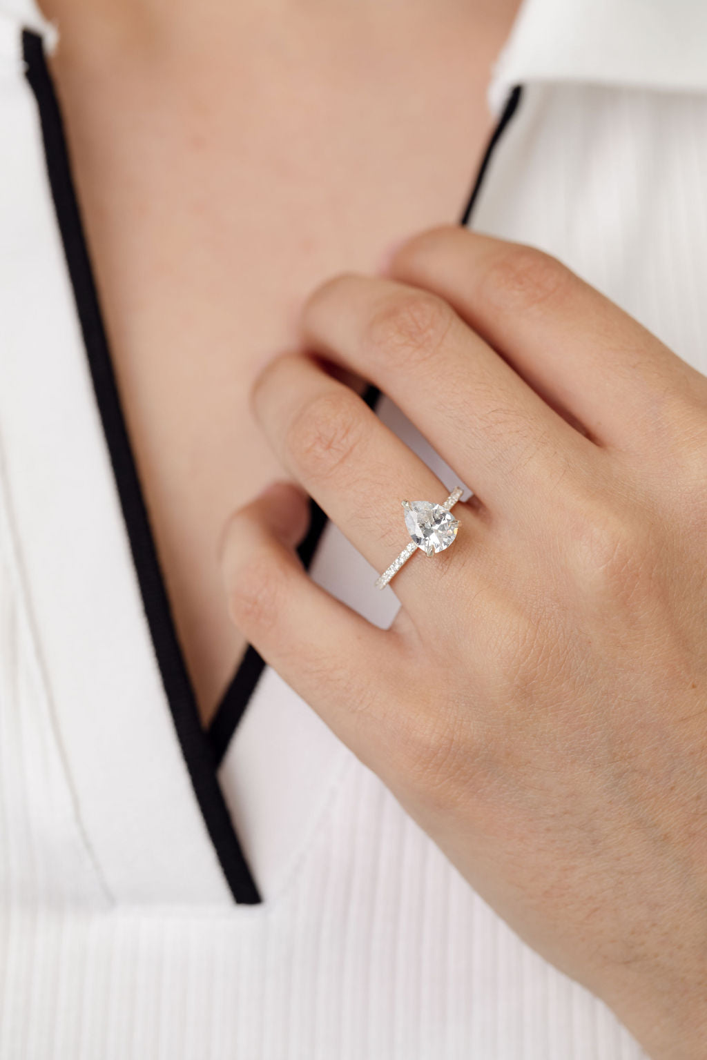 Pear cut diamond engagement ring with diamonds on the band