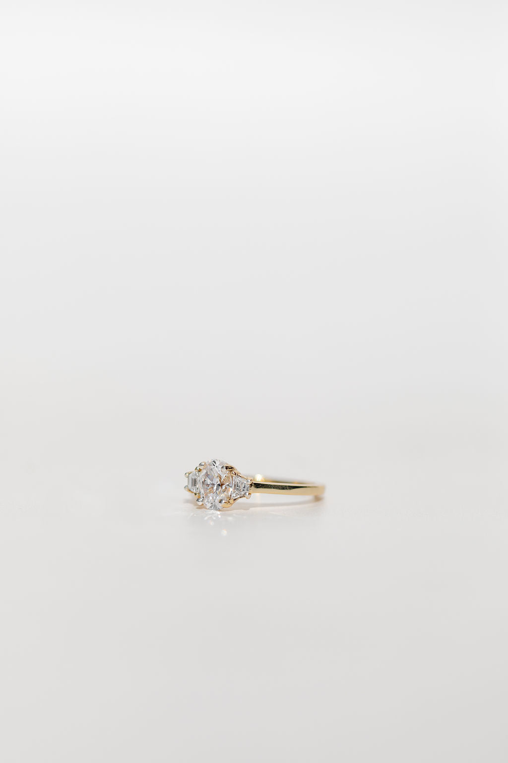 Three stone diamond engagement ring with oval centre and trapezoid side stones