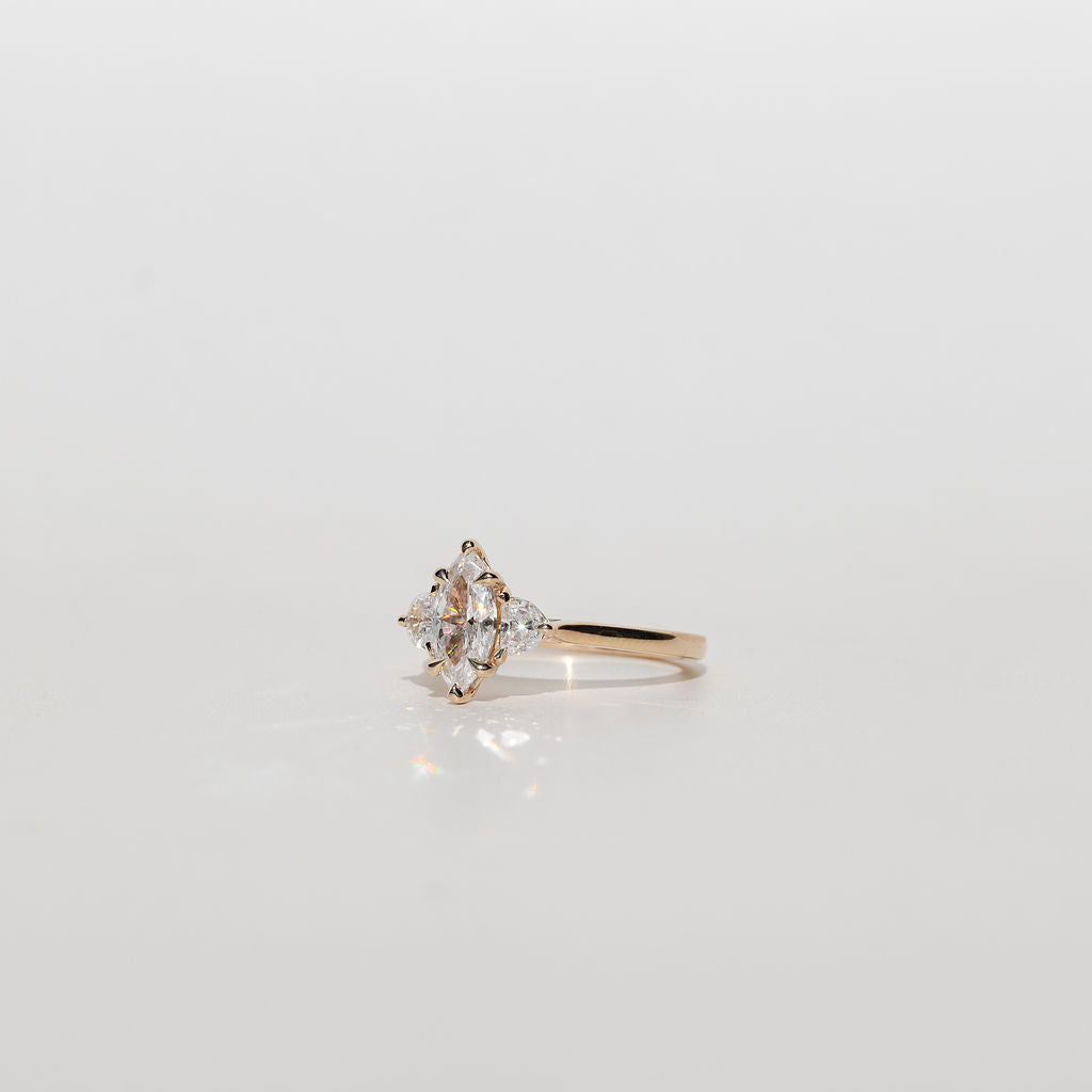 Three stone diamond engagement ring with marquise centre stone and half moon cut diamond side stones