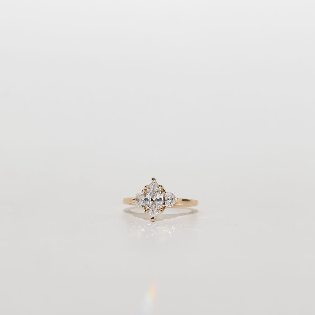Three stone diamond engagement ring with marquise centre stone and half moon cut diamond side stones