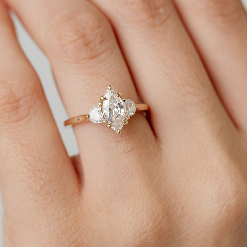 Three stone diamond engagement ring with marquise centre stone and half moon cut diamond side stones
