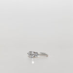 Trilogy engagement ring with a round cut diamond centre and brilliant cut side stones