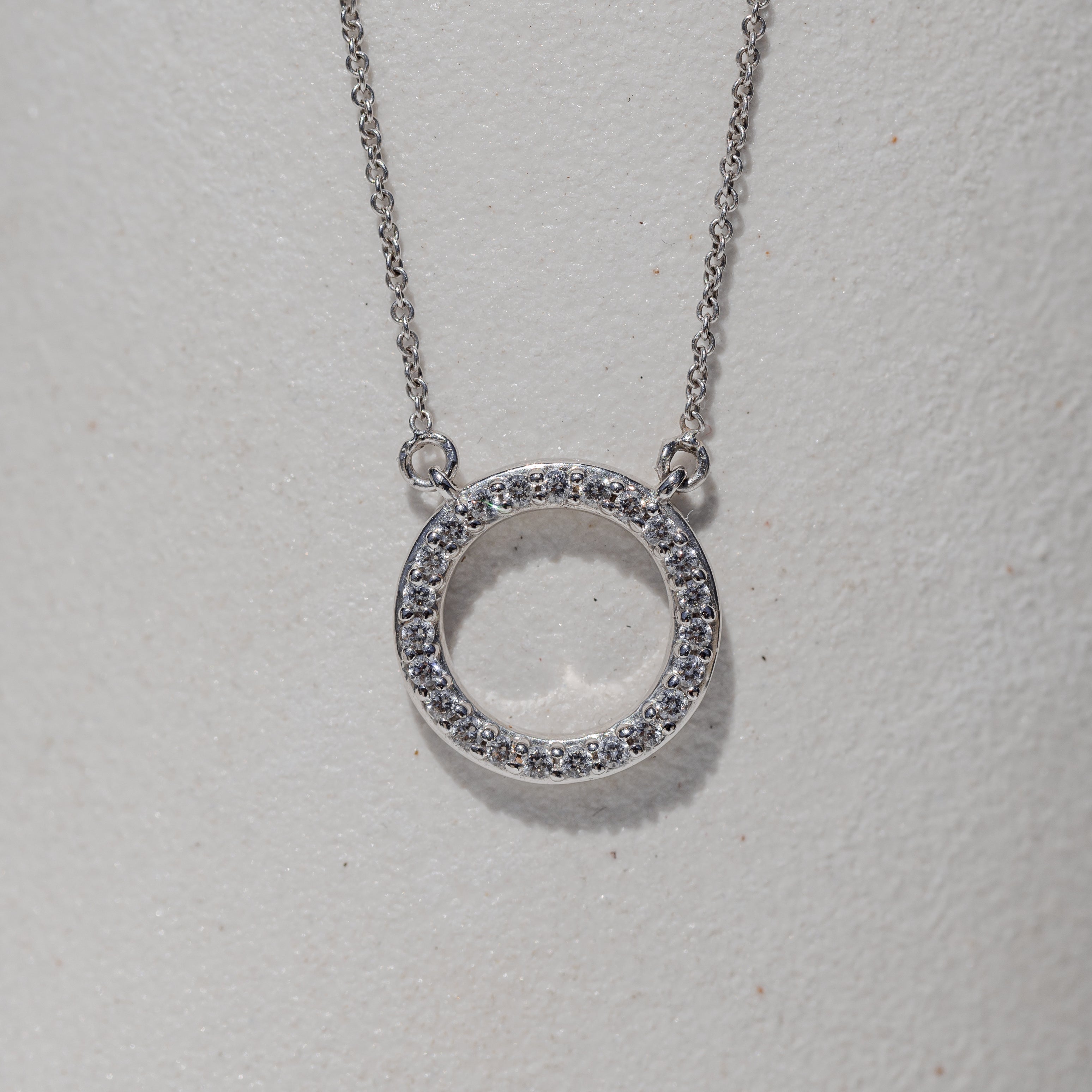 circle pendant with a halo of diamonds 