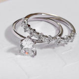 white gold diamond wedding ring with marquise diamonds and round diamonds and white gold engagement ring with pear solitaire diamond