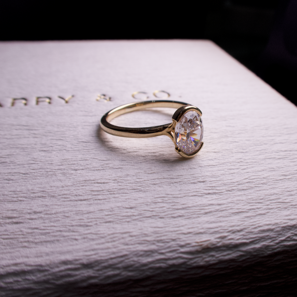 oval diamond engagement ring half bezel set in gold