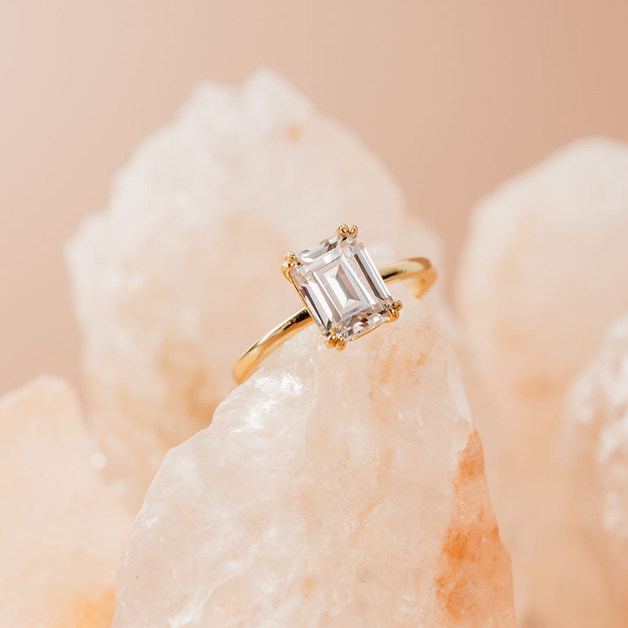 emerald cut diamond engagement ring with double claws in yellow gold