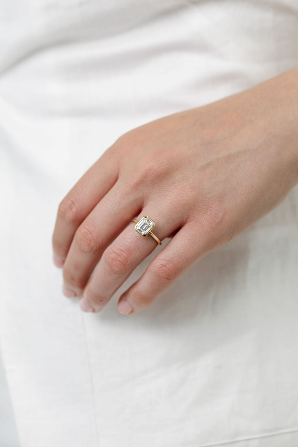 emerald cut diamond bezel set engagement ring