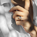side set oval engagement ring with diamond wedding ring on a woman with a white shirt