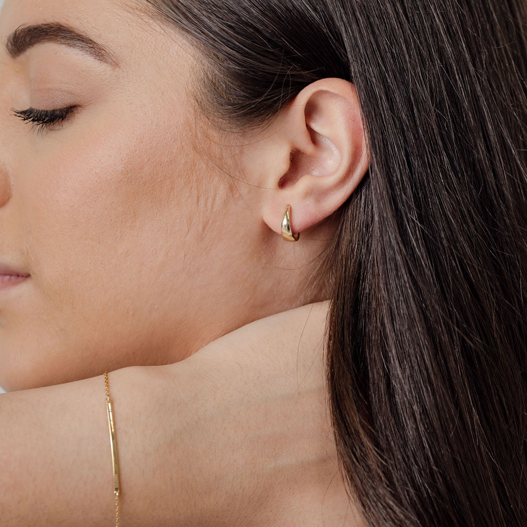 tapered gold huggie earrings and gold bar bracelet
