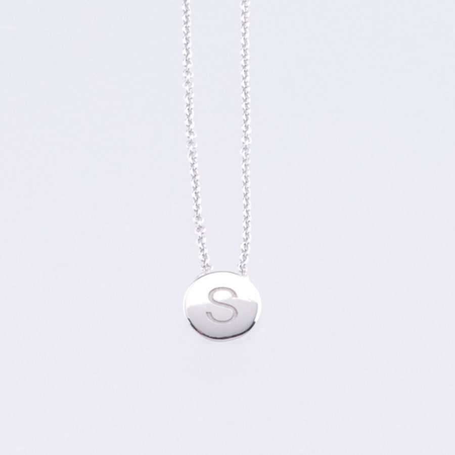 White gold disc pendant with engraved letter