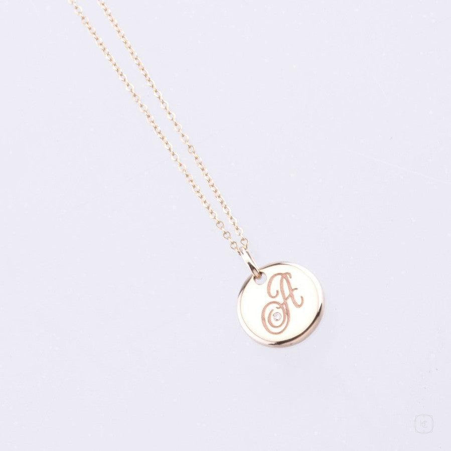 yellow gold disc pendant with engraved letter