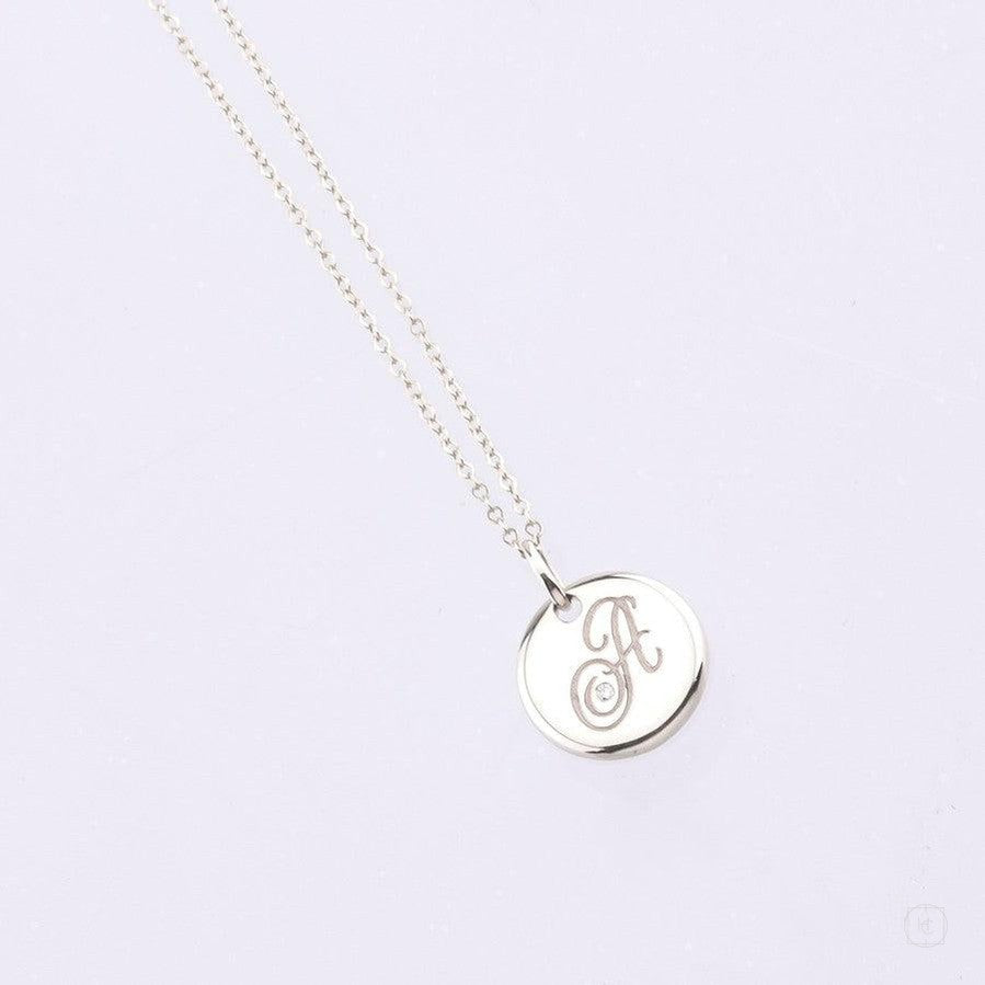 white gold disc pendant with engraved letter