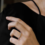 woman wearing white gold diamond ring against a black top