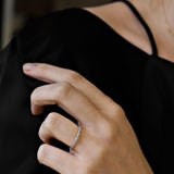 woman wearing white gold diamond ring against a black top