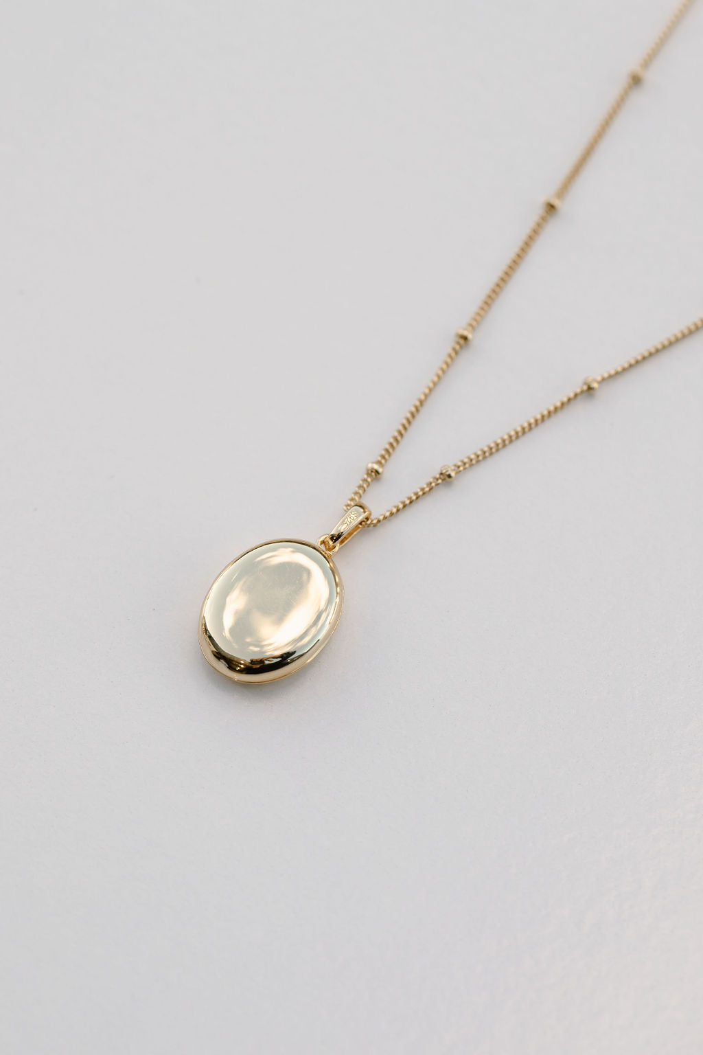 gold oval locket on bead chain necklace