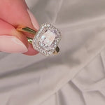 Elongated cushion cut engagement ring with a halo and millgrain detail