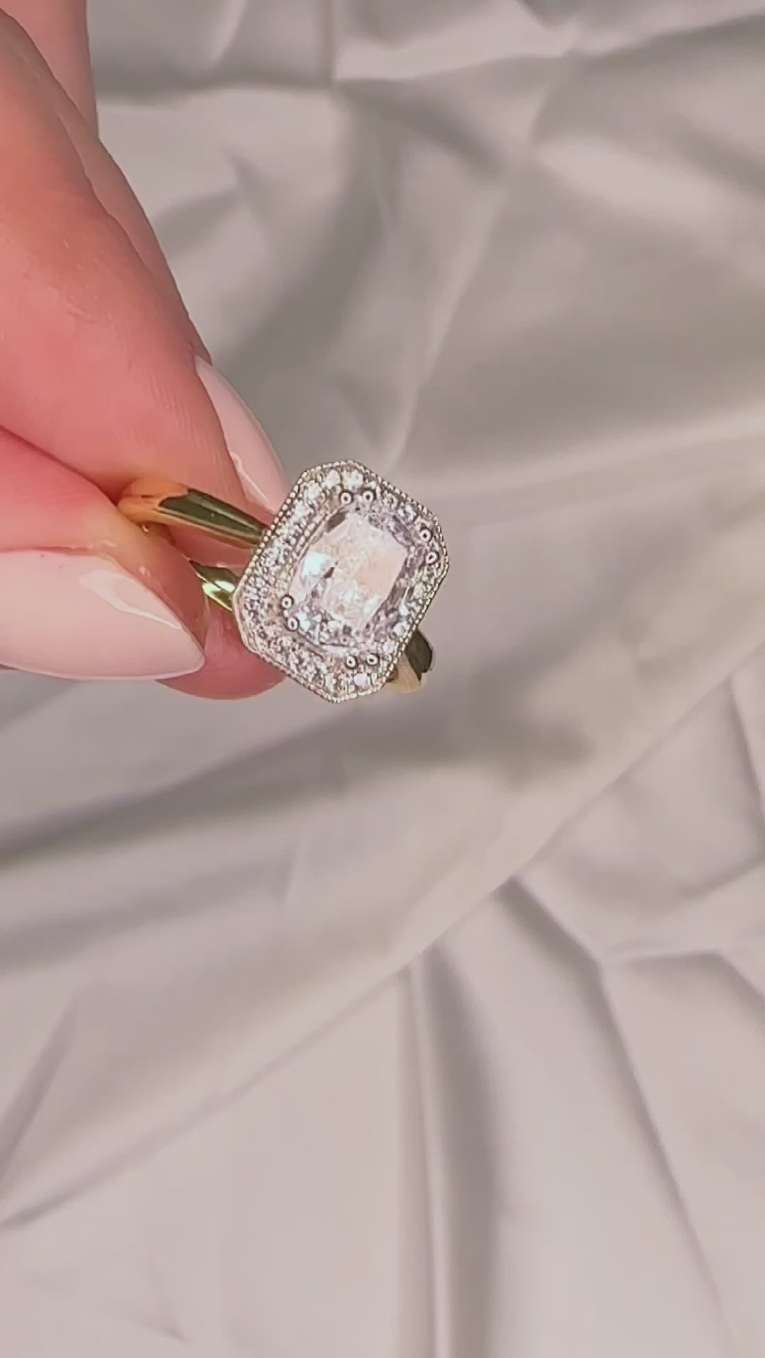 Elongated cushion cut engagement ring with a halo and millgrain detail
