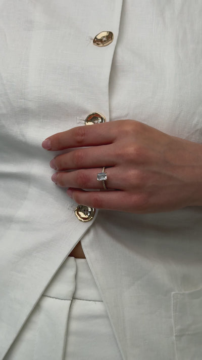 Emerald cut diamond engagement ring with diamond pave band
