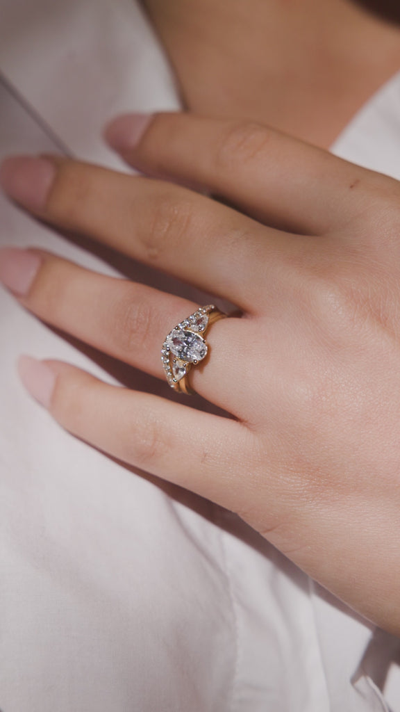 Trilogy 3 stone engagement ring oval cut diamond with pear cut side stones and a pave diamond wedding ring