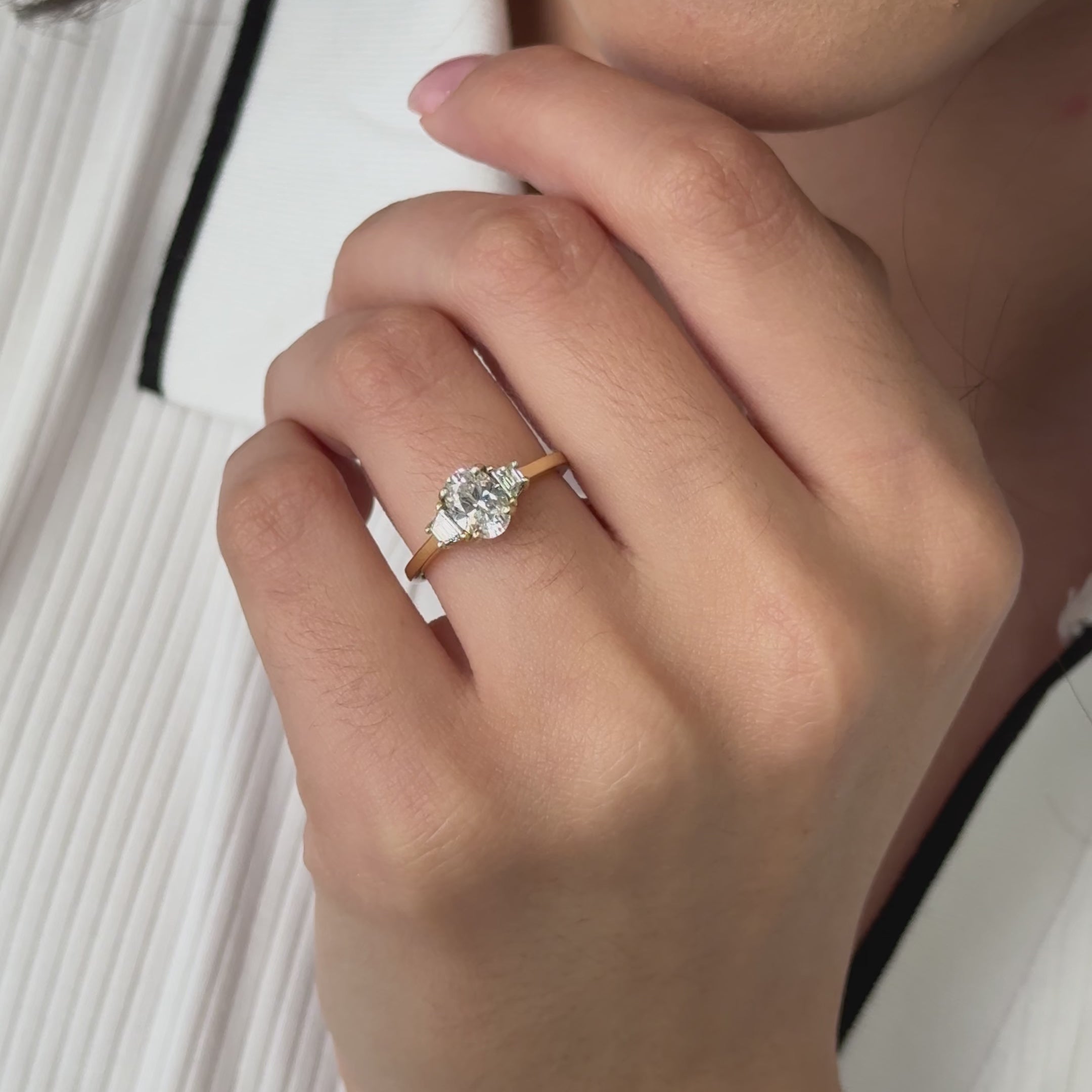Three stone trilogy engagement ring with oval cut diamond centre